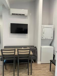 a dining room with a table with chairs and a tv at Modern 1-bedroom Studio with Kitchen and Laundry in Santa Clarita