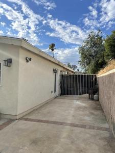 a white building with a gate and a fence at Modern 1-bedroom Studio with Kitchen and Laundry in Santa Clarita +2 photos