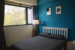 una camera da letto blu con un letto e una finestra di Kinmen Fujian Homestay a Tung-chou