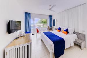 a hotel room with a bed and a television at Trinco Blu by Cinnamon in Trincomalee