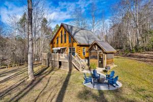 ein großes Holzhaus mit blauen Stühlen davor in der Unterkunft Woodland Ridge - Private 3 Bedrooms with Hot Tub in Sevierville