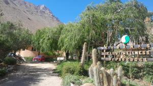 a sign in front of a building with a mountain at elquiwellness Cochiguaz in Cochiguaz
