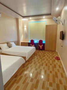 a hotel room with a bed and two chairs at thieuki 1 in Hà Tĩnh +7 photos