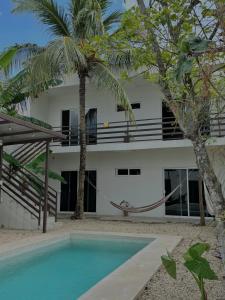 a villa with a hammock in front of a house at Apartamento Casa 24 in Bacalar