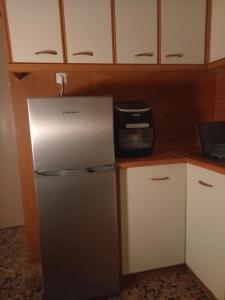 a refrigerator in a kitchen with white cabinets at Bamboo garden in Nea Iraklia +28 photos