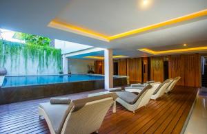 a room with a swimming pool and some chairs and a swimming pool at Mahalaksmi Boutique Hotel in Sanur