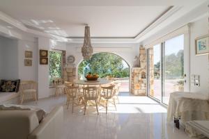 a white living room with a table and chairs at Cretan Biosuites in Palaiokastro