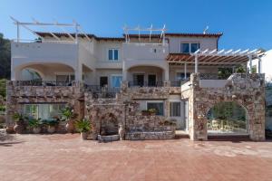 a large white house with a stone wall at Cretan Biosuites in Palaiokastro