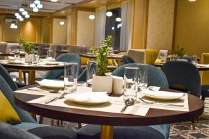 斋浦尔Urban Suites by BluSalzz, Jaipur - Rajasthan的用餐室配有桌椅、盘子和玻璃杯