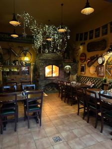 a restaurant with tables and chairs and a stone fireplace at Shoemaker Irish Pub & Accommodation in Kielce