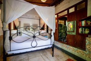 een slaapkamer met een wit bed met een hemelbed bij Unique Balian beach house in Antasari