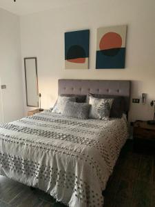 Un dormitorio con una cama y dos cuadros en la pared. en casa kiwi playa del carmen, en Playa del Carmen