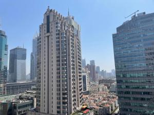 a tall white building in the middle of a city at 上海柠檬汁民宿 Shanghai lemon juic B&B-Shanghai Lemon Deluxe Room 外滩南京西路步行街 in Shanghai