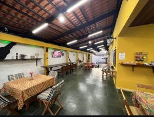 a restaurant with a table and chairs and a yellow wall at Casarao hostel dormitorio in Cuiabá