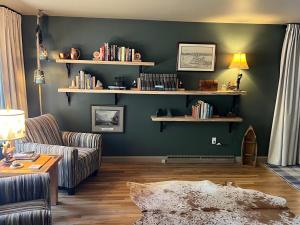 a living room with a couch and shelves with books at Cabin on the Creek with Fireplace, Game Room, and Firepit in Colorado City