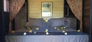 a bed with flowers on top of it at Pension LE PASSAGE in Vaitoare