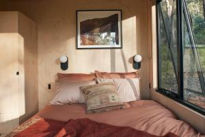 a bed in a small room with a window at Ribbon Gum Retreat in Reidsdale