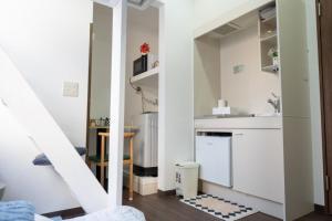 una pequeña cocina con paredes blancas y una escalera en 王202整套私人卫浴厨房 洗衣机 车站步行5分钟 上野站地铁直达, en Tokio