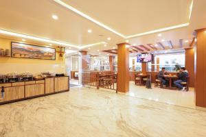 um lobby de um restaurante com pessoas sentadas em mesas em Magnificent Hotel em Catmandu