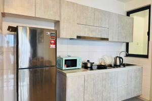 プトラジャヤにあるWarm Family Stay-IOI City Mallの冷蔵庫と電子レンジ付きのキッチン