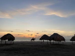 a person riding a horse on the beach at sunset at Casa Española del Mar in Cartagena de Indias