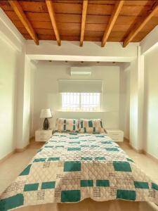 a large bed in a white room with a wooden ceiling at Casa Española del Mar in Cartagena de Indias