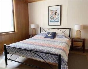 a bedroom with a bed with a blue pillow on it at Oli's at 57 Lakeside Drive, Mallacoota in Mallacoota