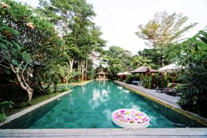 a swimming pool with a float in the middle at Kropak Canggu in Canggu