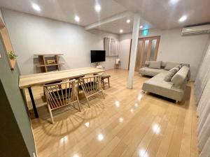 a living room with a table and a couch at お宿あさのは in Kagoshima