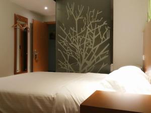 a bedroom with a large white bed with a wall at Vatica ShangDong Heze Mudan Road Shangri-La Square Hotel in Heze