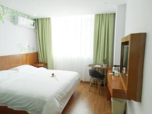 Habitación de hotel con cama, escritorio y espejo. en Vatica ShangDong Heze Mudan Road Shangri-La Square Hotel, en Heze