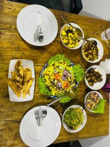 a wooden table with plates of food on it at Villa kandupamula in Mirissa
