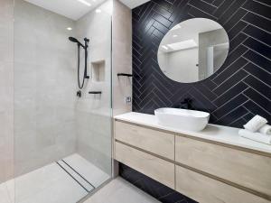 un bagno con lavandino e specchio di Cotton Tree Beach Front 3 Bedroom Townhouse a Maroochydore Altre 5 foto