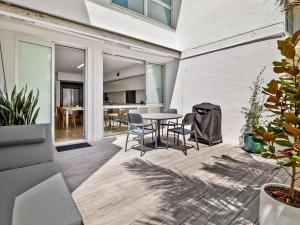 un patio aperto con tavolo e sedie di Cotton Tree Beach Front 3 Bedroom Townhouse a Maroochydore