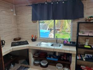 a kitchen with a sink and a window at Pearl house in Fare