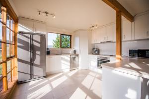 a kitchen with white cabinets and a large window at Charles Reuben Estate in Hobart