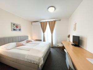 a bedroom with a bed and a desk with a computer at Pension Ingrid in Neutal