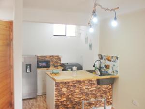 a kitchen with a stone counter and a refrigerator at Departamento amplio, moderno, Cusco Perú in Cusco +27 photos