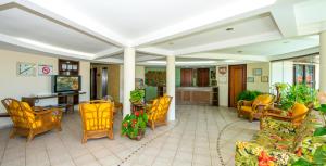 a living room with yellow chairs and a table at Divi-Divi Praia Hotel in Natal