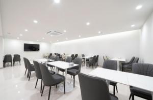 光州Cheomdan Lantana Hotel的摆放着白色桌椅的餐厅