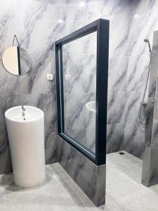 ein Badezimmer mit Waschbecken und Dusche mit Spiegel in der Unterkunft Swiss-Belexpress Rest Area KM 166 Cipali 