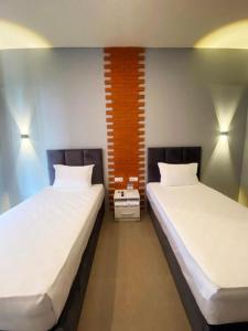 zwei Betten nebeneinander in einem Zimmer in der Unterkunft Swiss-Belexpress Rest Area KM 166 Cipali 