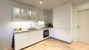 Una cocina con gabinetes blancos y un fregadero. en Cozy Ocean View Apartment in Hoyvk, Faroe Islands, en Hoyvík 8 fotos más