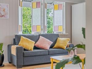 a living room with a blue couch and windows at Silkstone Cottage in Bundamba +18 photos