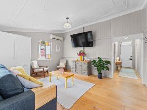 a living room with a couch and a tv at Silkstone Cottage in Bundamba