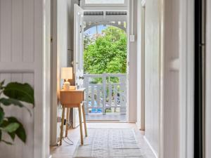 an open door to a balcony with a table and a lamp at Silkstone Cottage in Bundamba