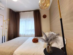 a bedroom with a bed with a vase on a table at B23新宿最中心 大久保站7分-Shinjuku center 7 mins to St, Max 5 直达新宿 涉谷 表参道 池袋 上野 代代木 银座 原宿 in Tokyo