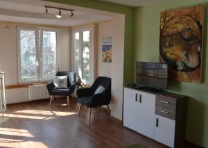 a living room with two chairs and a flat screen tv at Pan Tadeusz pokoje gościnne in Siemiatycze