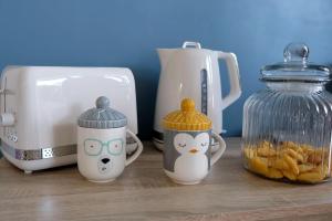 three hello kitty cups sitting on a counter next to a toaster at Collioure, appartement clair, terrasse et parking in Collioure