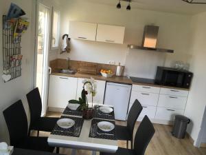 a kitchen with a table with chairs and a tableasteryasteryasteryasteryasteryastery at Collioure, appartement clair, terrasse et parking in Collioure